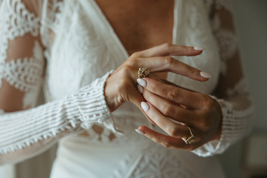 Bride puts on her heirloom jewelry in Miramar Beach destination wedding