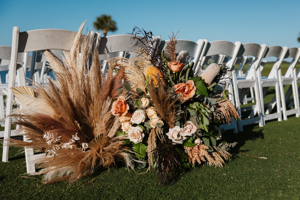Floral arrangements with pampas grass at Miramar Beach wedding 