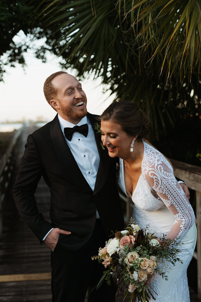 Bride and groom laugh together at Miramar Beach destination wedding
