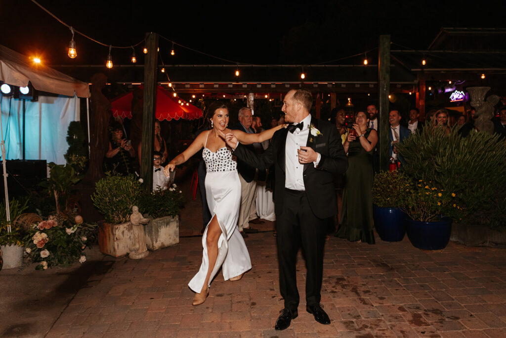 Bride and groom step onto the dance floor in their grand entrance as newlyweds at Louis Louis in South Walton, Florida