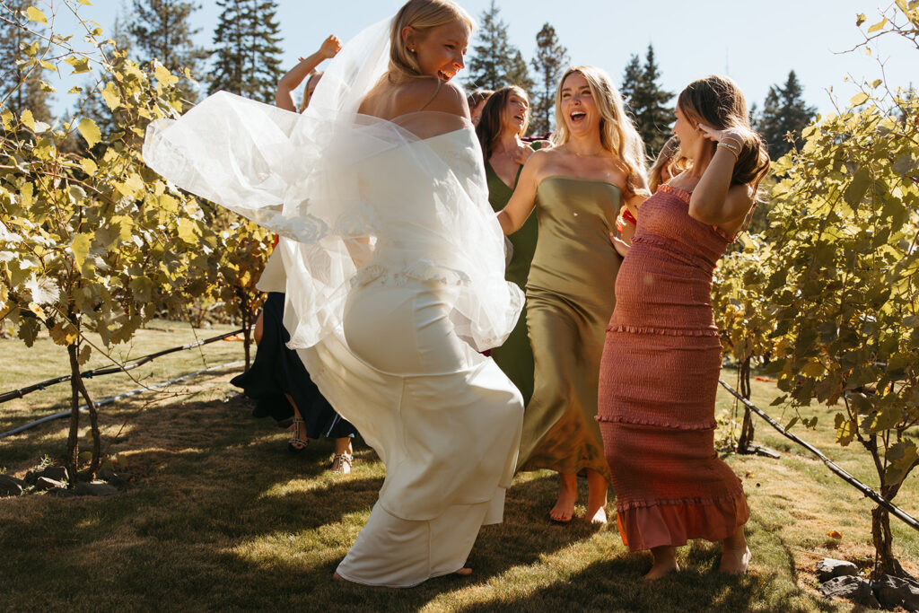 Bride dances in Idaho field as her bridesmaids cheer her on.