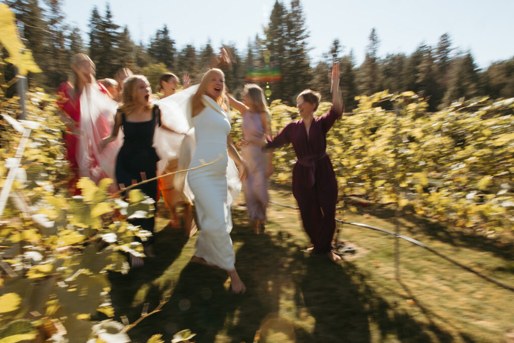 Bride and bridesmaids dance through Idaho vineyard.