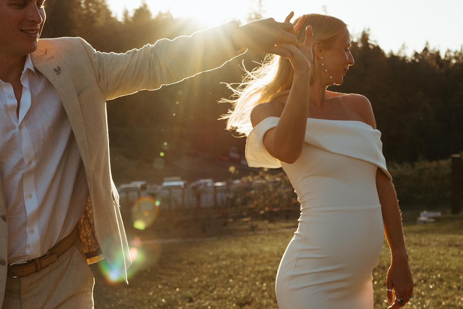 Groom twirls bride in carefree dance in Idaho field.