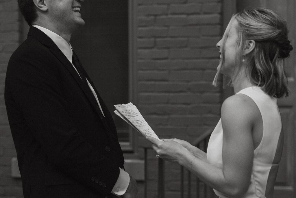 Bride and groom both laugh in private vow exchange at courthouse wedding