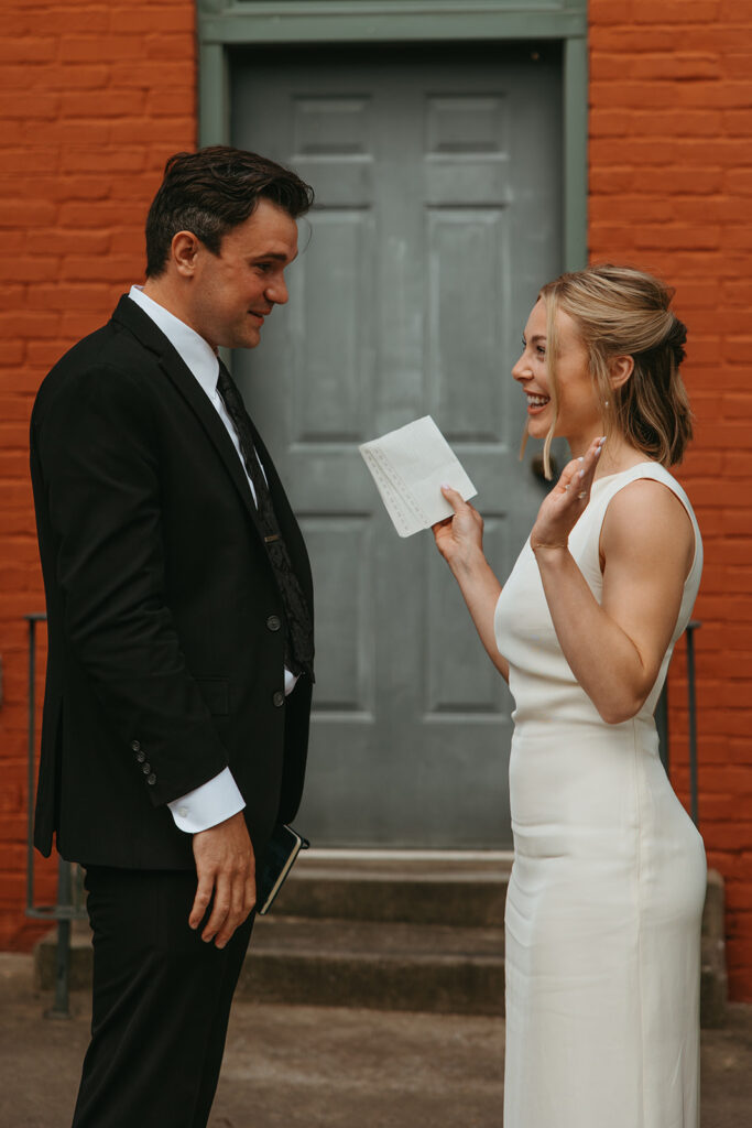 Bride holds her hands up to signify she is done reading her vows