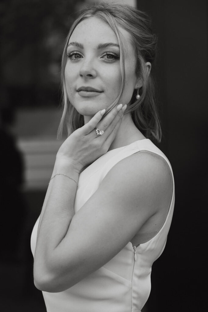 Portrait of bride cupping her face as she looks at the camera