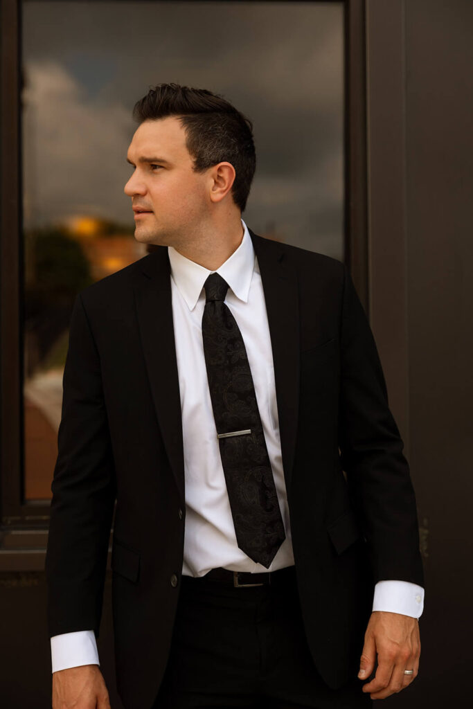 Portrait of groom as he looks off into the distance