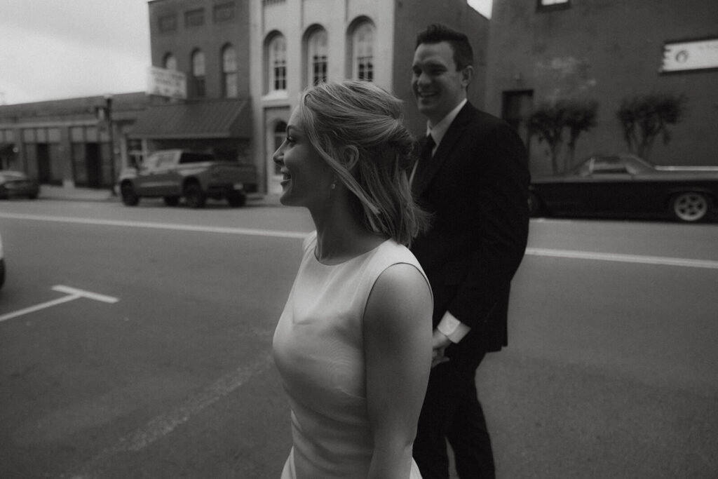 Cinematic shot of bride and groom walking up and down Main Street on intimate courthouse wedding day