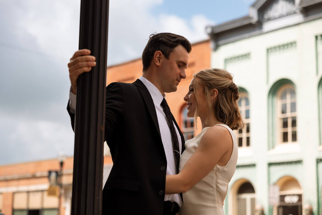 Groom looks down at bride as she smiles at him