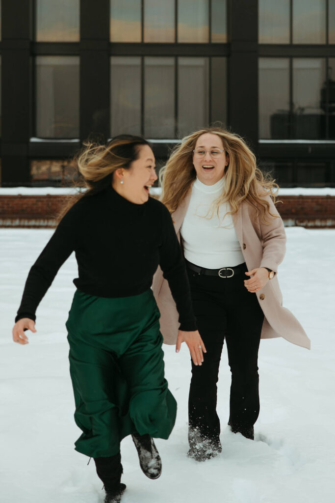 Engaged couple chases each other through a snowy rooftop in downtown Nashville.