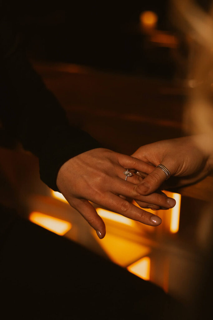 Engaged woman displays oval cut engagement ring.