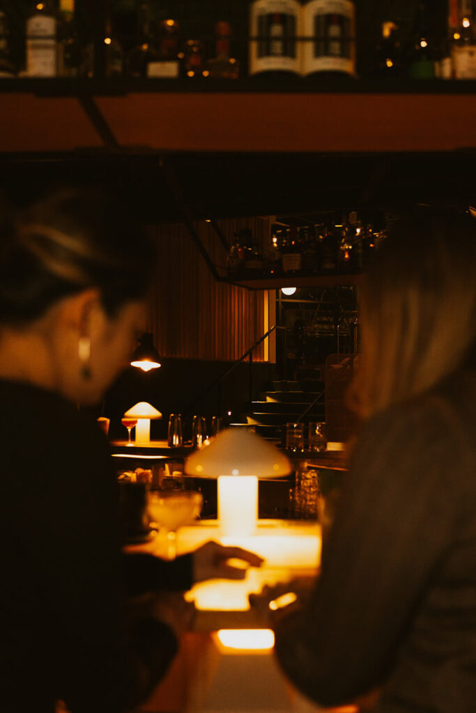 Blurry image of couple looking at the cocktail menu at Present Tense Restaurant in Nashville, Tennessee.