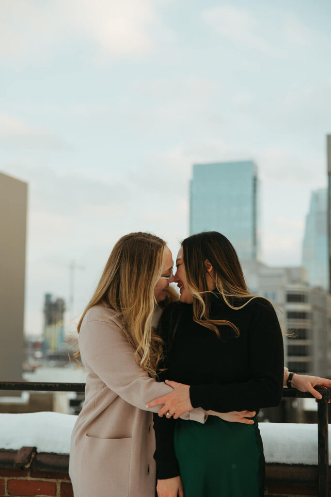 Engaged couple leans in for a kiss with the Nashville skyline behind them during their mini-moon.