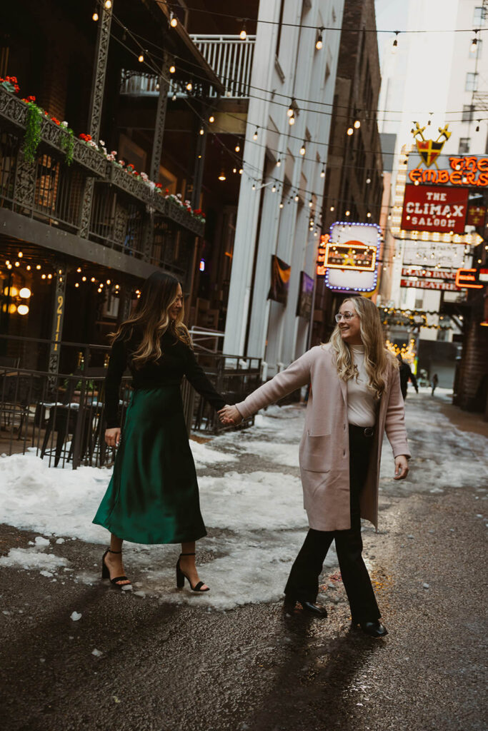 Engaged couple walks through the empty streets of Printer's Alley.