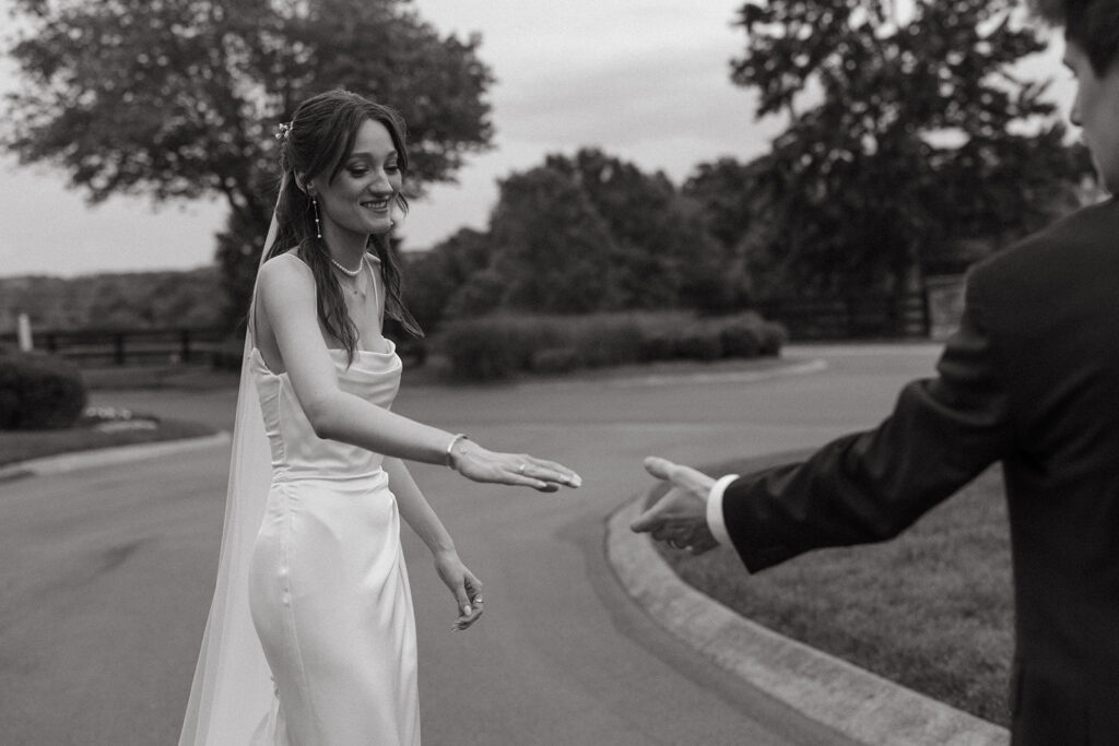 Bride reaches for groom's hand in documentary style wedding photos