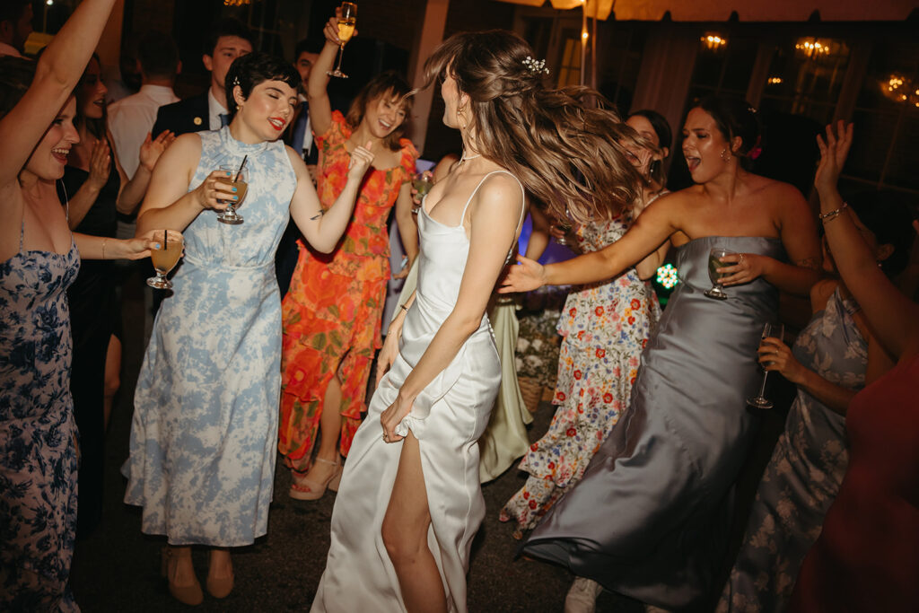 Bride dances at wedding reception surrounded by all of her girlfriends