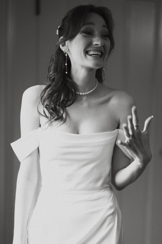 Elated bride shows off her wedding ring in her bridal portraits