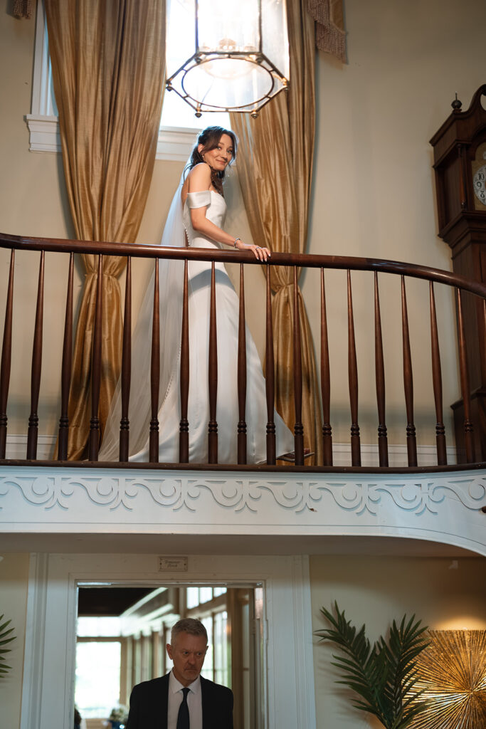 Bride comes down the stairwell for first look with her dad in documentary style wedding photos