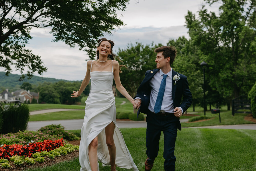 Bride and groom run and skip through Governer's Club courtyard in Brentwood, Tennessee