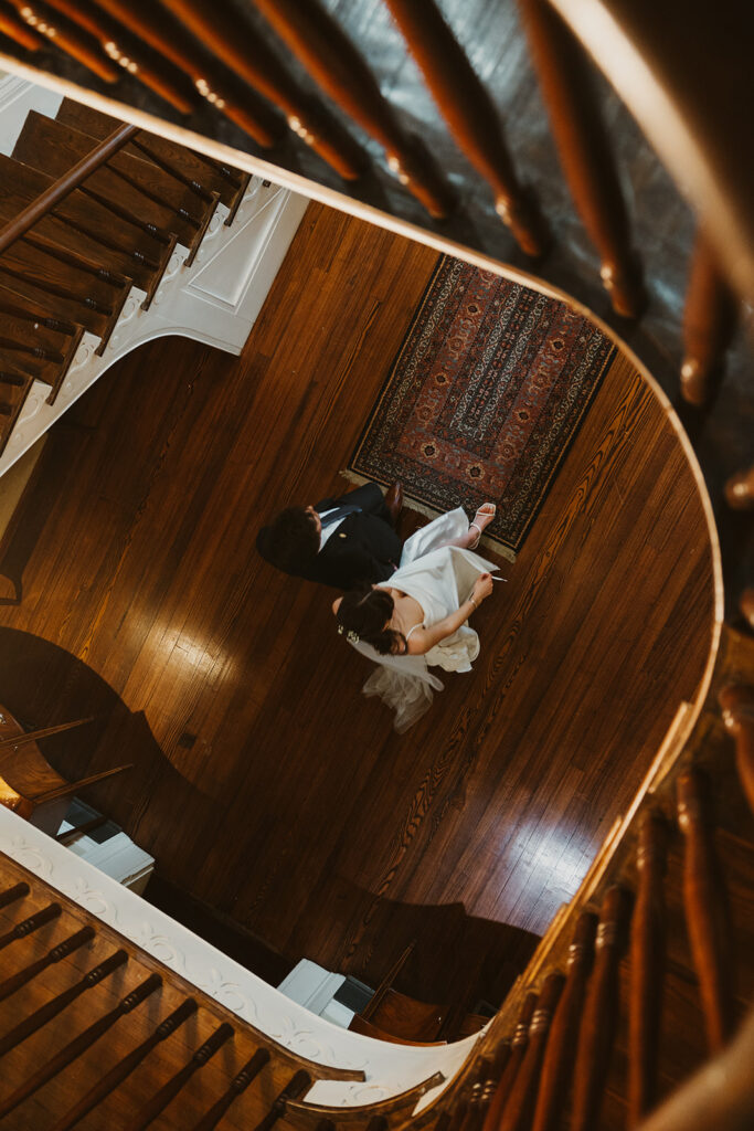 Aerial view of bride and groom on hardwood floors while walking over a vintage rug