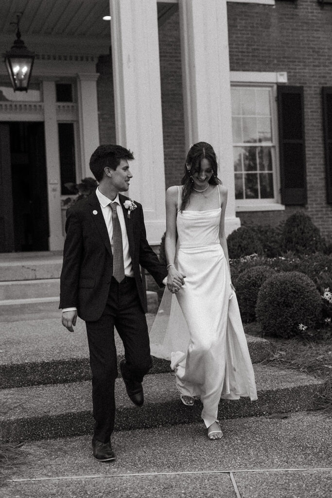 Bride and groom in conversation as they come down the steps of Pleasant Hill Mansion in Brentwood, Tennessee