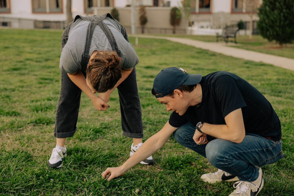 Engaged couple searches for four leaf clovers