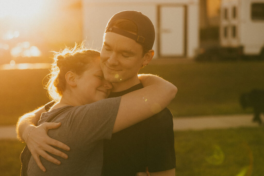 Man and woman with their eyes closed embrace in Nashville golden hour