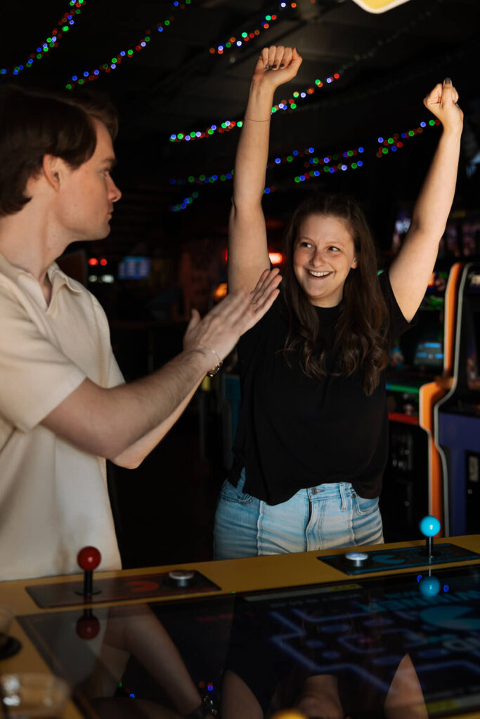 Engaged couple celebrates a win while playing arcade games in Nashville engagement photoshoot