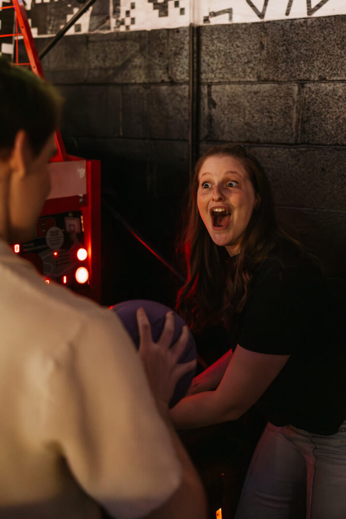 Woman reacts in surprise at having won game of basketball at Nashville arcade