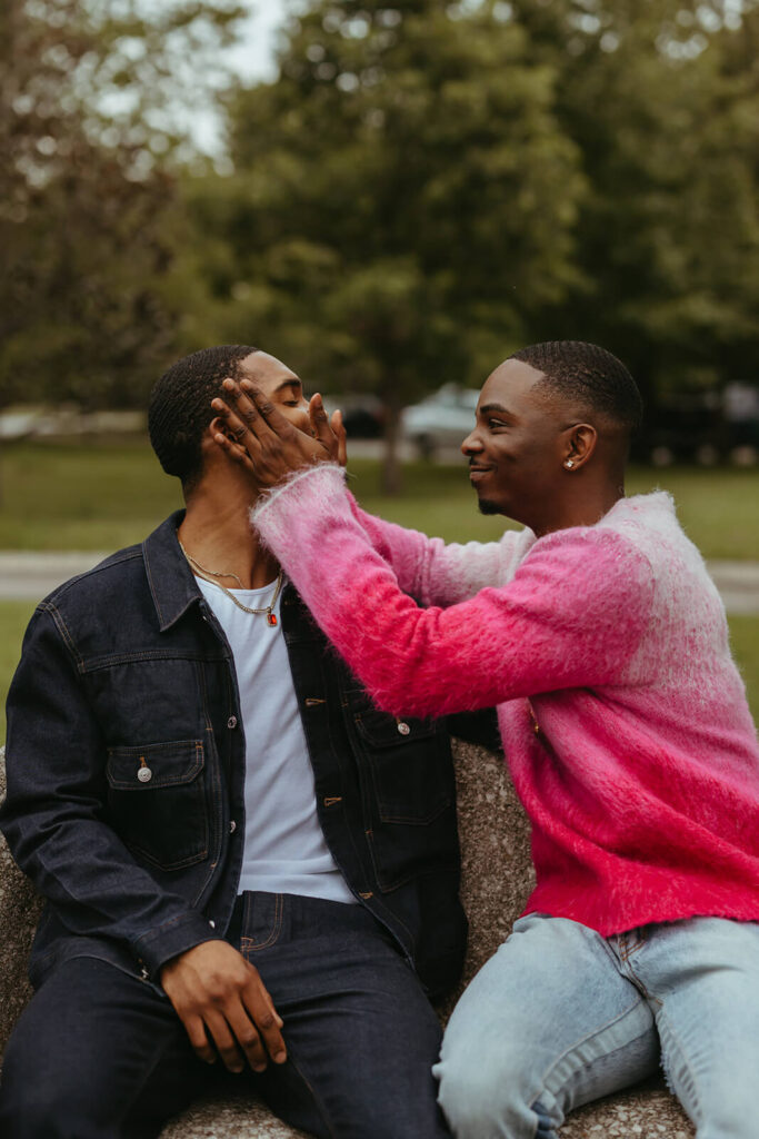 Man cups his hands jokingly around his fiance's face in Nashville engagement photoshoot