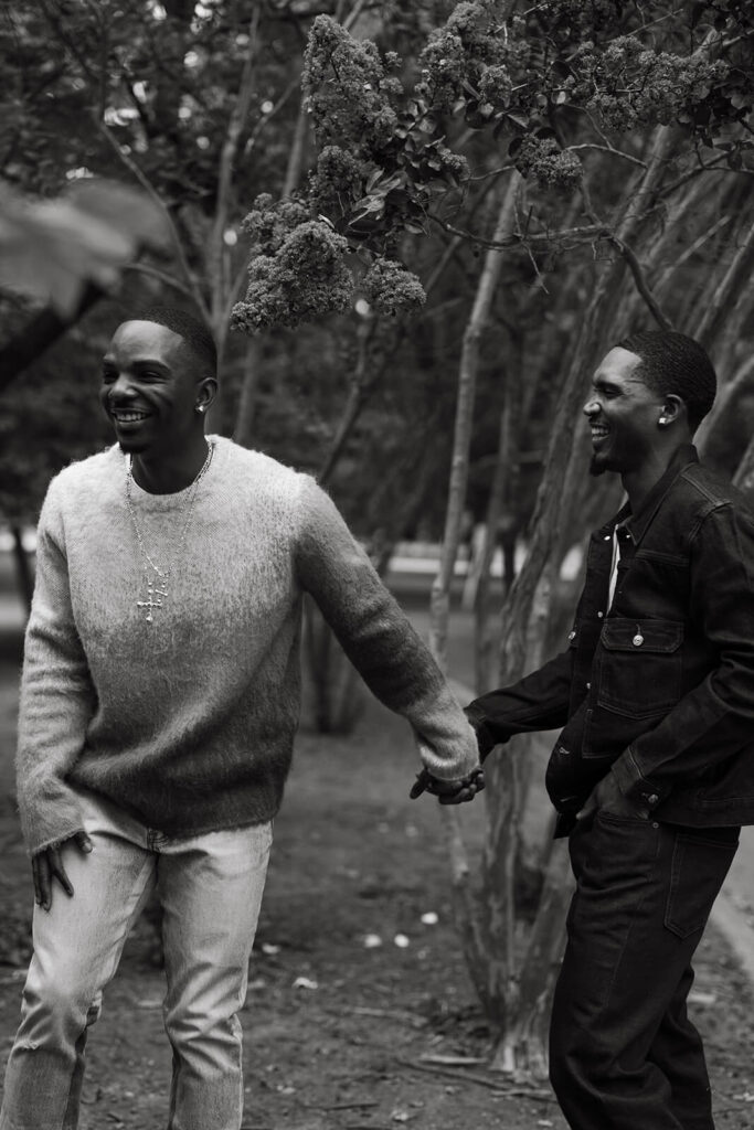 Couple holds hands and laughs under magnolia trees in Nashville