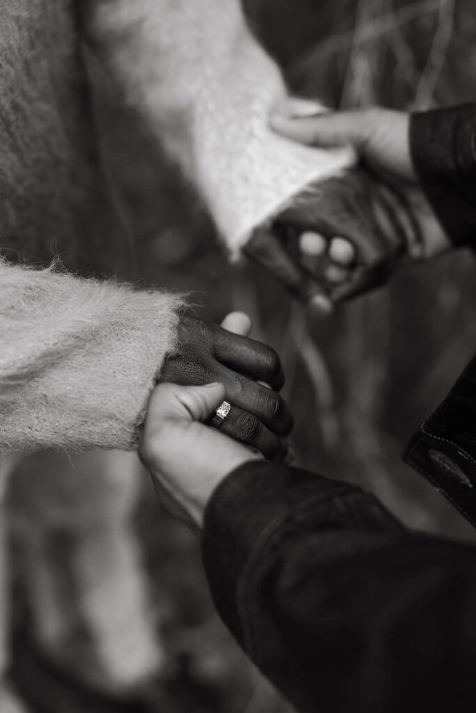 Couple holds hands following their engagement, showing off the new ring