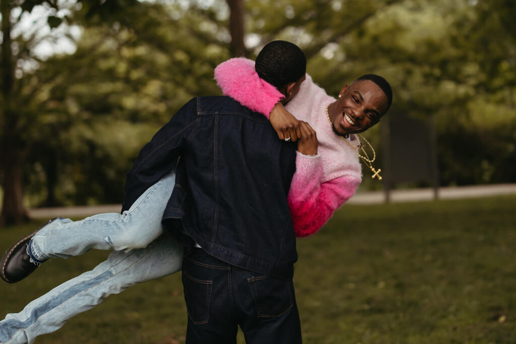 Man swings his fiance around in the air while he laughs joyously