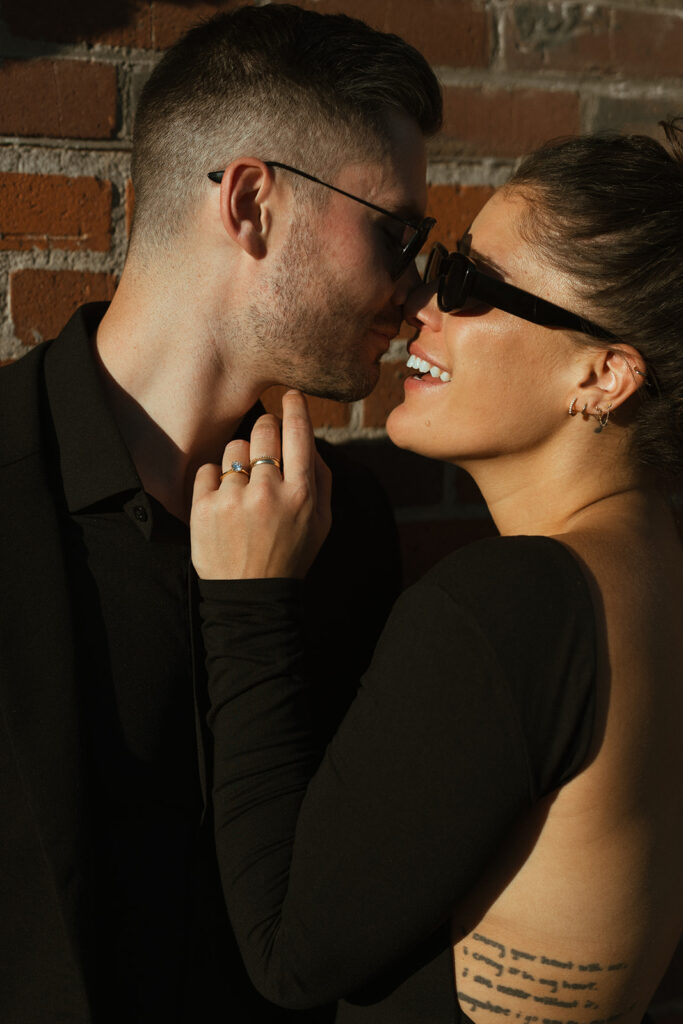 Man and woman in sunglasses lean in for a kiss 