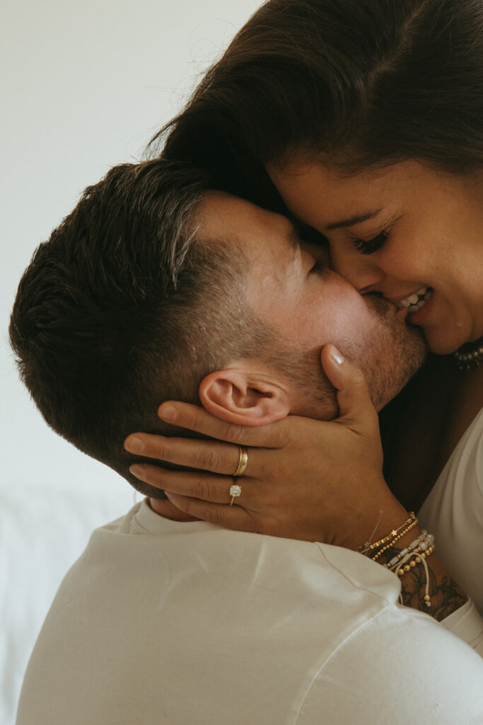 Woman bits her fiance's lip during engagement photoshoot