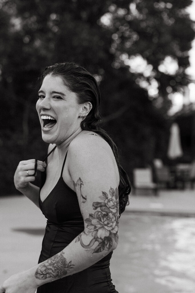 Woman laughs as she dries off after jumping in the pool