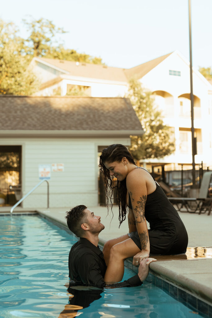 Woman sits on the edge of the pool as her husband talks to her while in the water