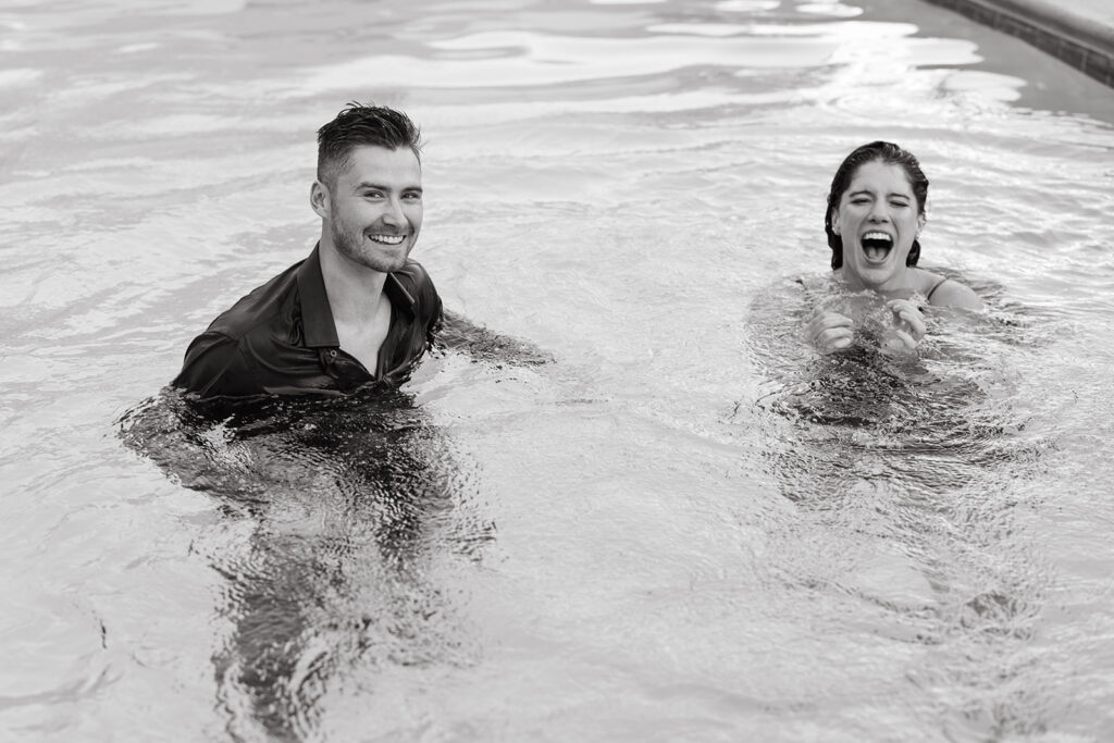 Engaged couple laughs after playing in the pool