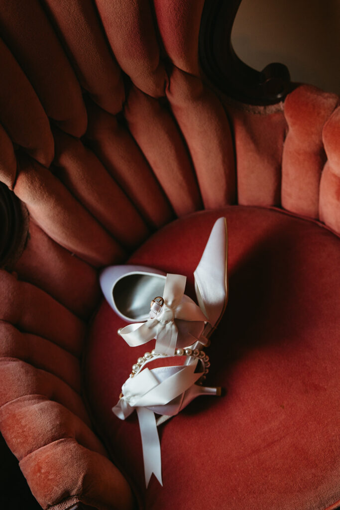 Bride's shoes rest on dark coral mid century mod chair