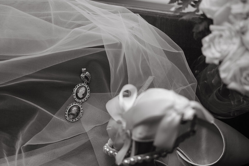 Bride's veil, shoes, and earrings rest on the vanity at Emerald Union bridal suite