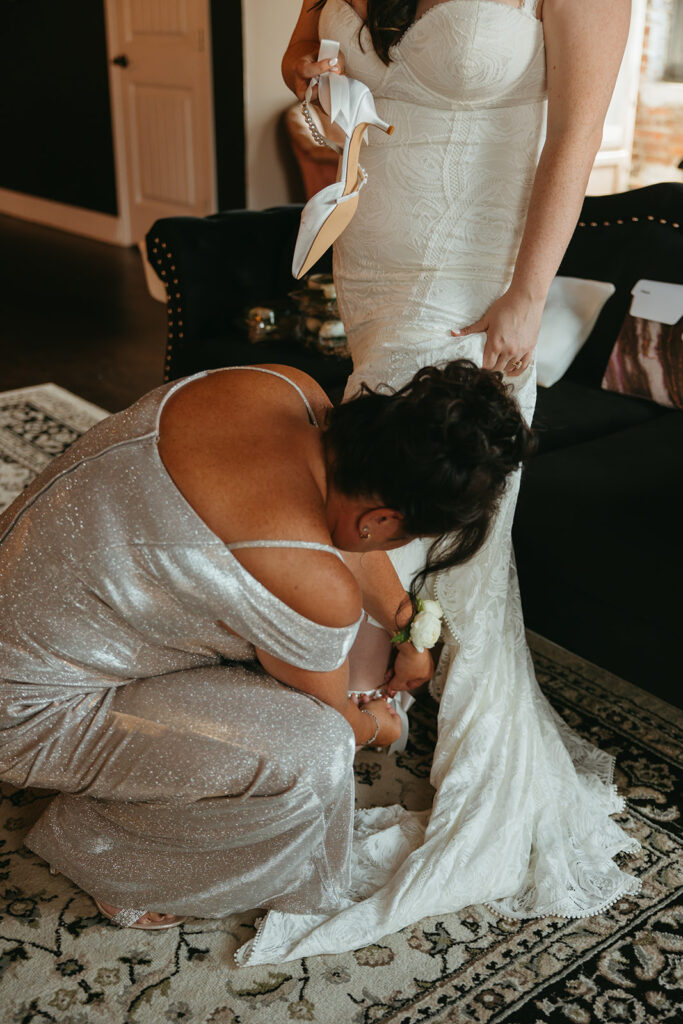 Mother of the bride helps bride fix her shoes