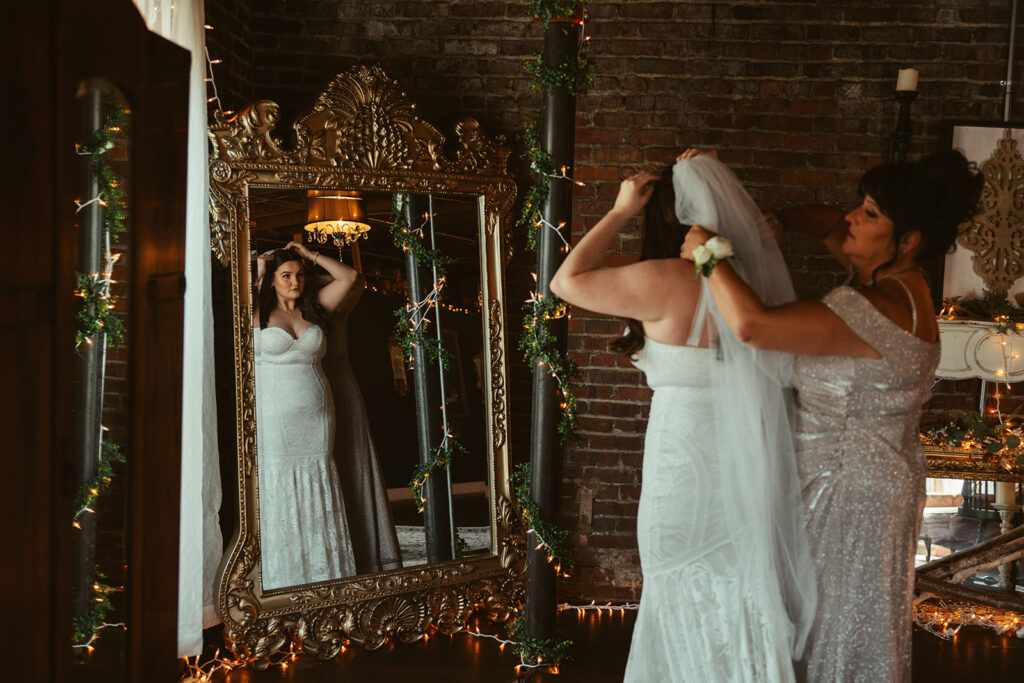 Mother of the bride fixes bride's veil in the bridal suite of wedding venue in Tennessee