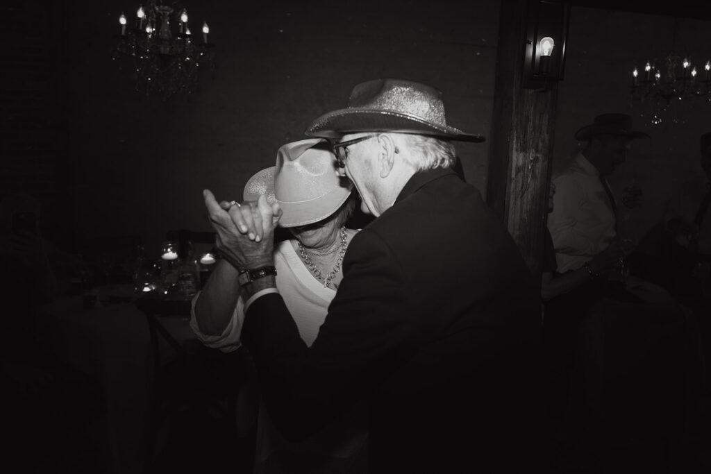 Grandma and grandpa dance with cowboy hats on during wedding reception at wedding venue in Tennessee