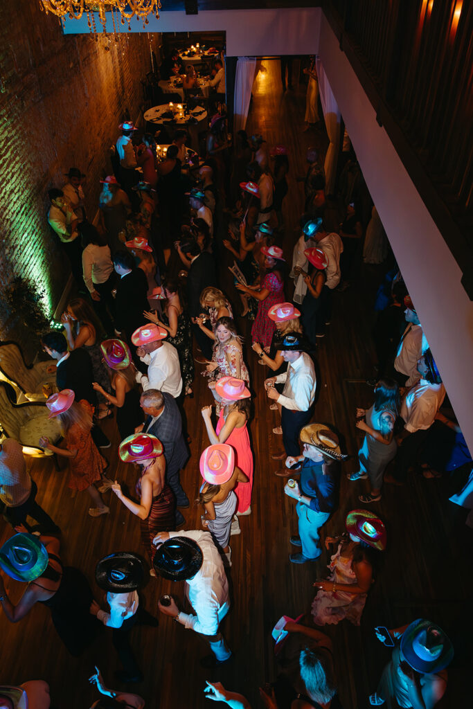 Aerial view of cowboy hat-wearing guests dancing at reception