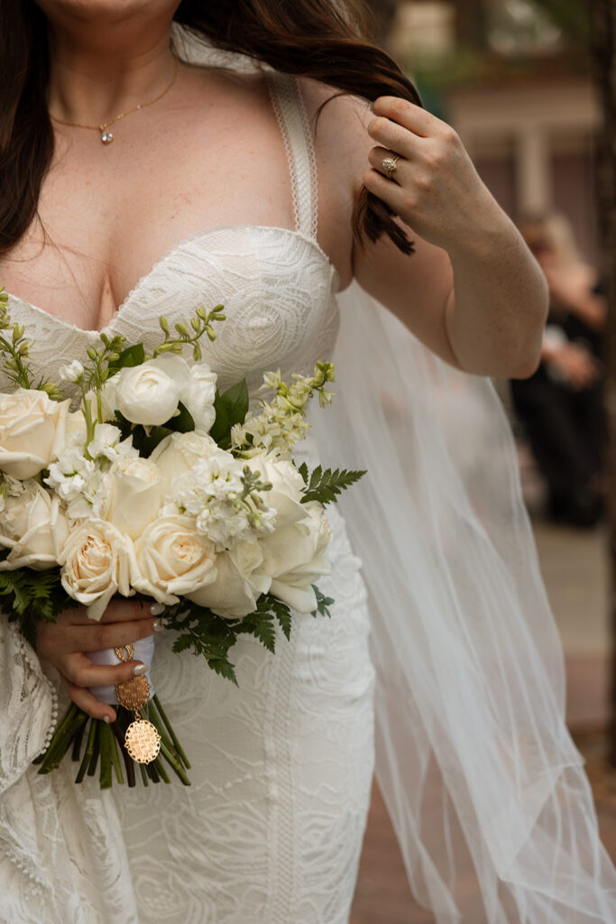 Bride fixes her hair while holding her beautiful bridal bouquet