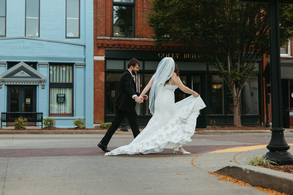 Bride and groom walk hand in hand down Gallatin Main Street outside wedding venue in Tennessee