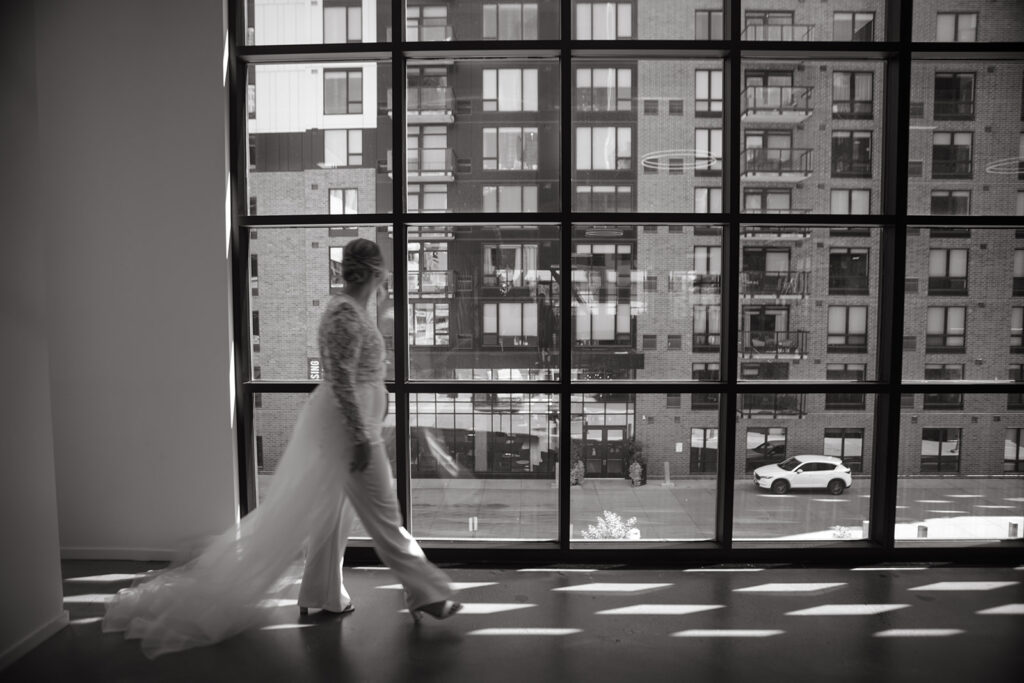 Bride walks in front of open panel windows at Minnesota wedding venue