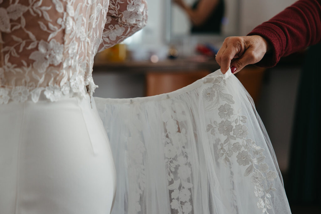 Bride's mother attaches skirt