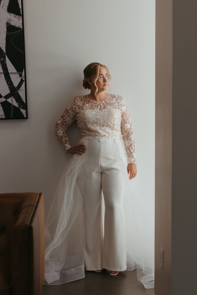 Bride poses in entryway with hand on hip