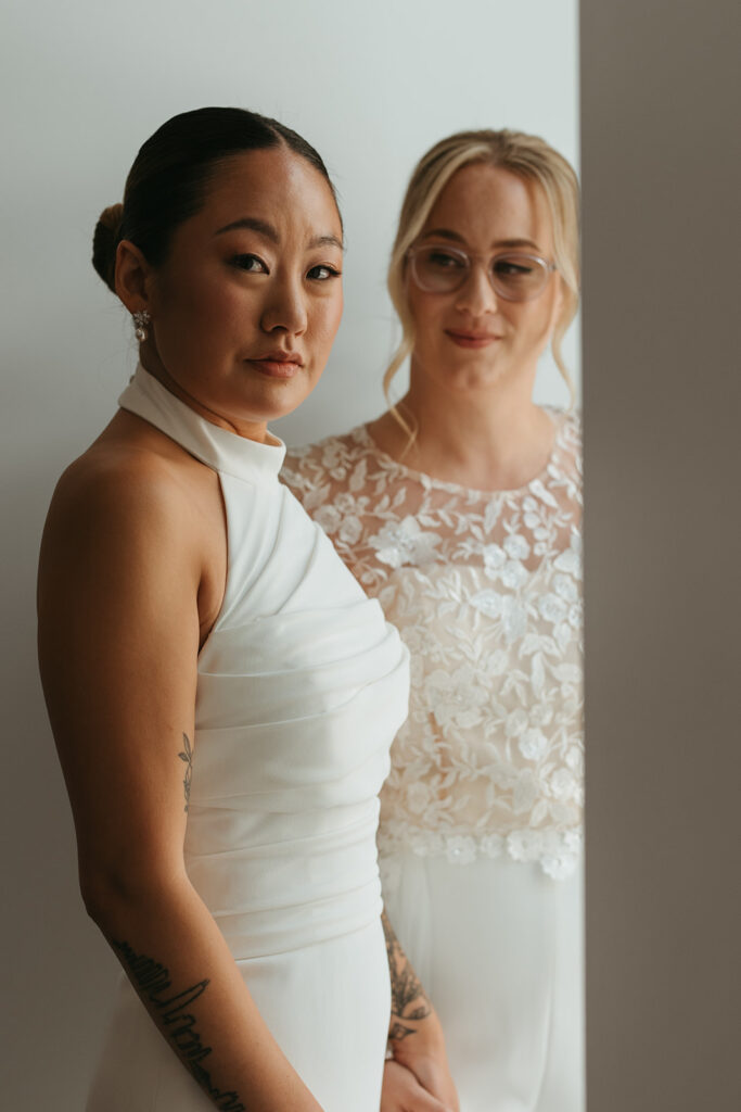 Bride looks on at other bride in Minneapolis queer wedding